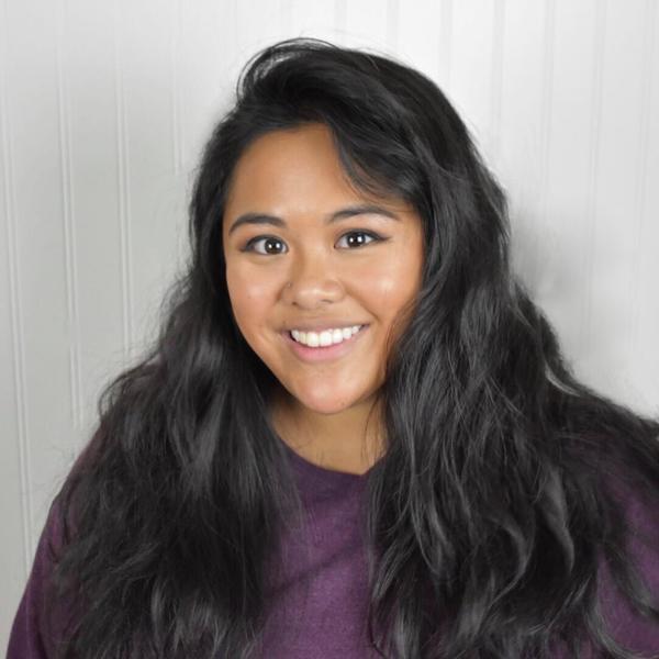 Headshot of Hannah smiling in front of a white background