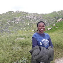 GSMP participant standing in green field on hike